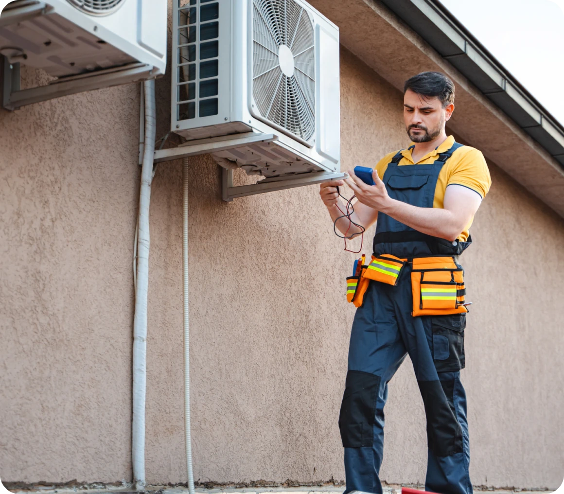 Technician checking outdoor air conditioning unit.